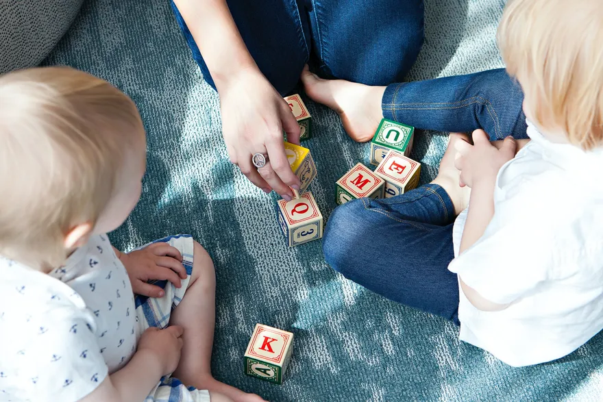 A young child concentrating while stacking colorful blocks during a therapy session